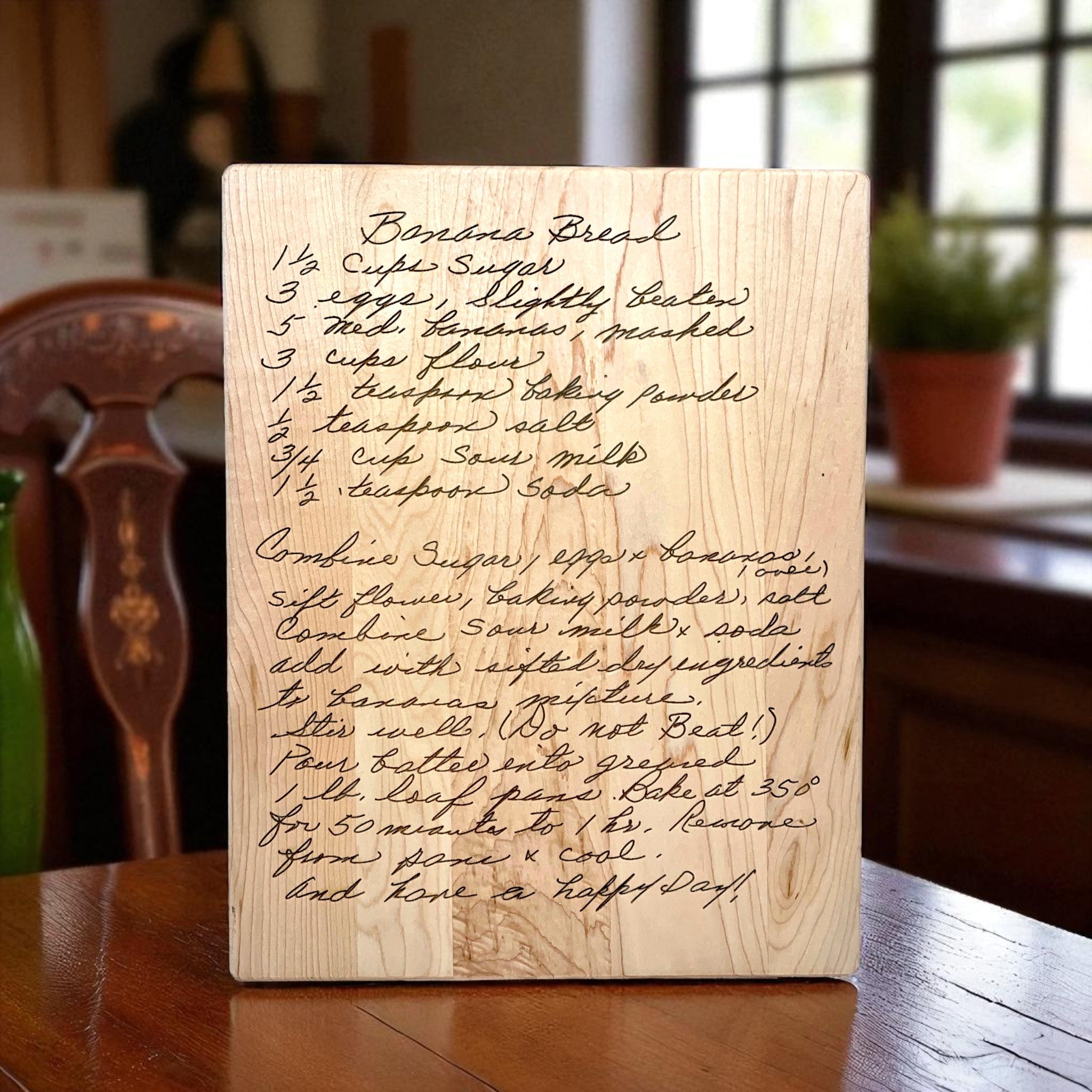 Wooden block with engraved recipe for banana bread on a wooden table.