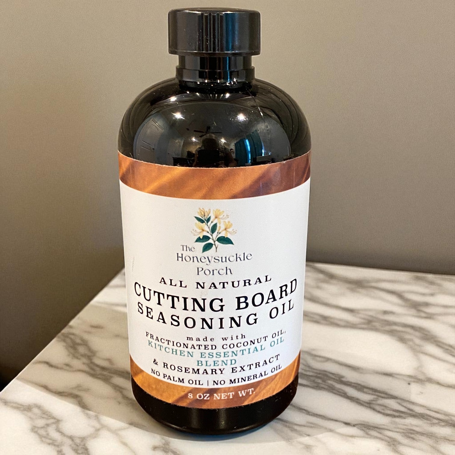 Bottle of all natural cutting board seasoning oil on a marble surface