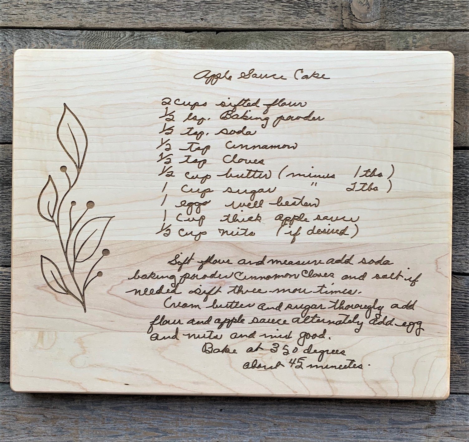 Maple cutting board with engraved handwritten Apple Spice Cake recipe on a wooden surface
