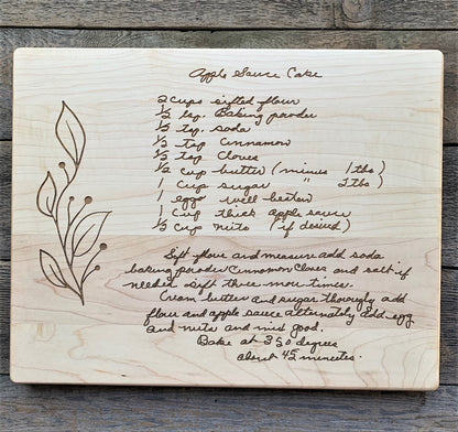 Maple cutting board with engraved handwritten Apple Spice Cake recipe on a wooden surface