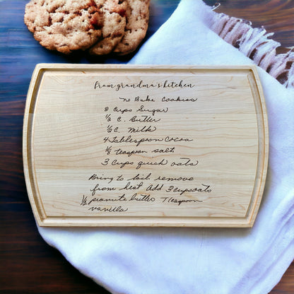 maple cutting board on dish towel with handwritten recipe for no bake cookies